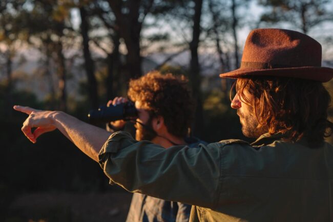 Exploring Kalahari's Feathered Wonders with men using binoculars