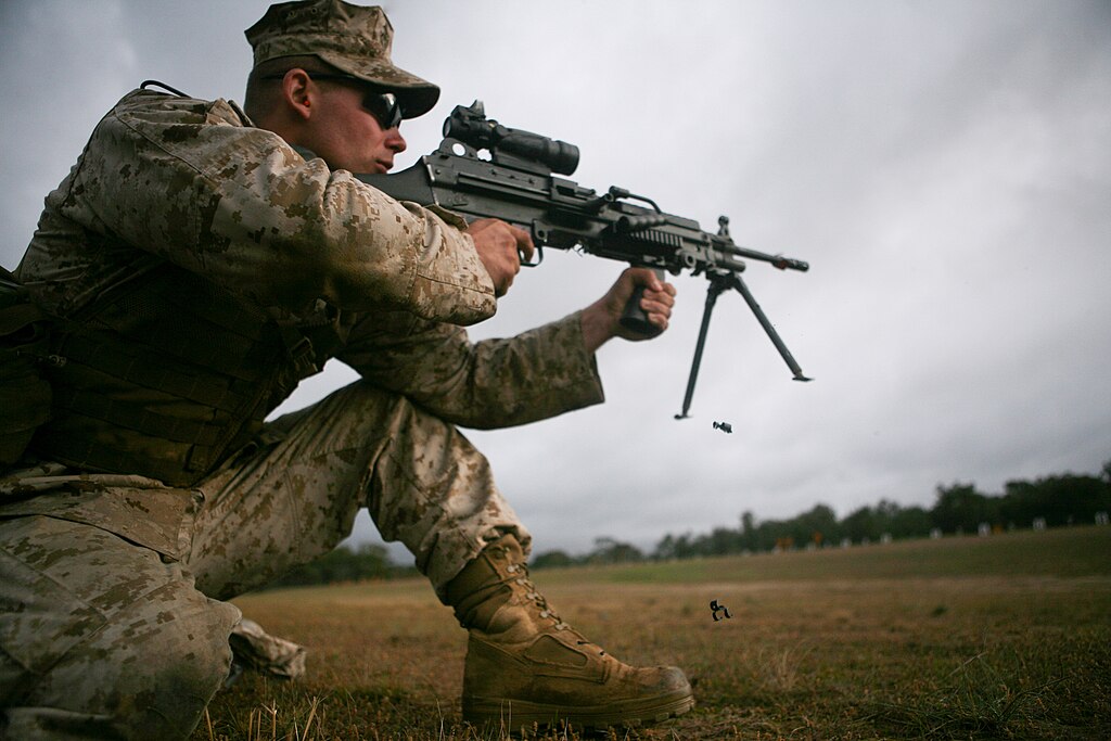 rifle safety and preparation illustrated by man in camouflage kneeling shooting rifle